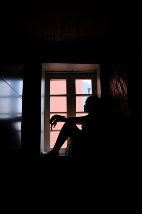 Free A silhouette of a person sitting in contemplation by a window in Porto, Portugal. Stock Photo
