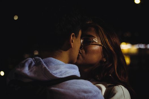 A couple shares an intimate kiss under the night sky in the heart of Ciudad de México.