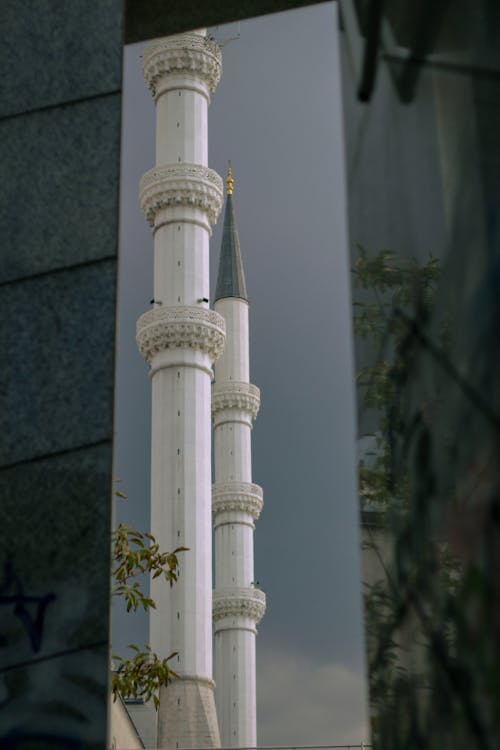 A tall white mosque with a reflection of the sky