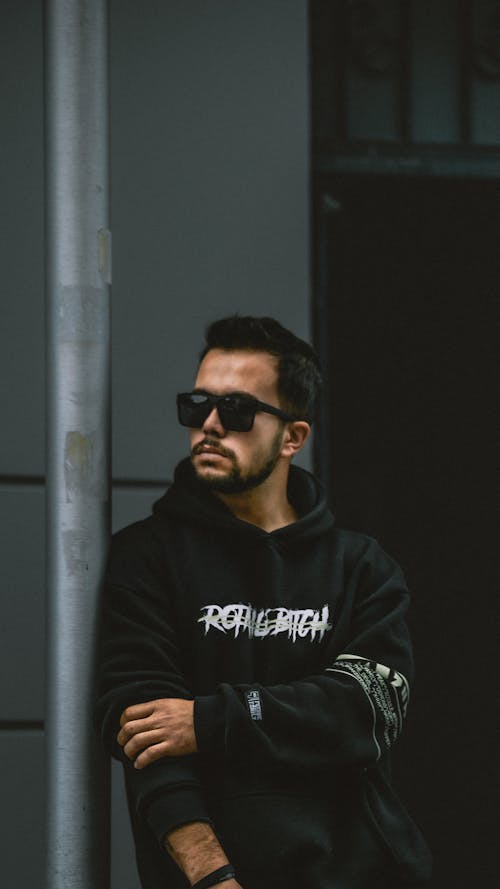 Man Posing in Black Hoodie and Sunglasses