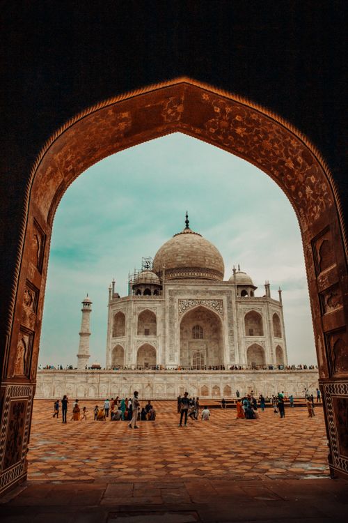 Free The iconic Taj Mahal viewed through a decorative arch with visitors in the foreground, Agra, India. Stock Photo