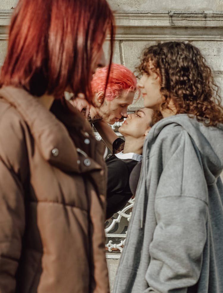 A Group Of Young People Standing Outside 