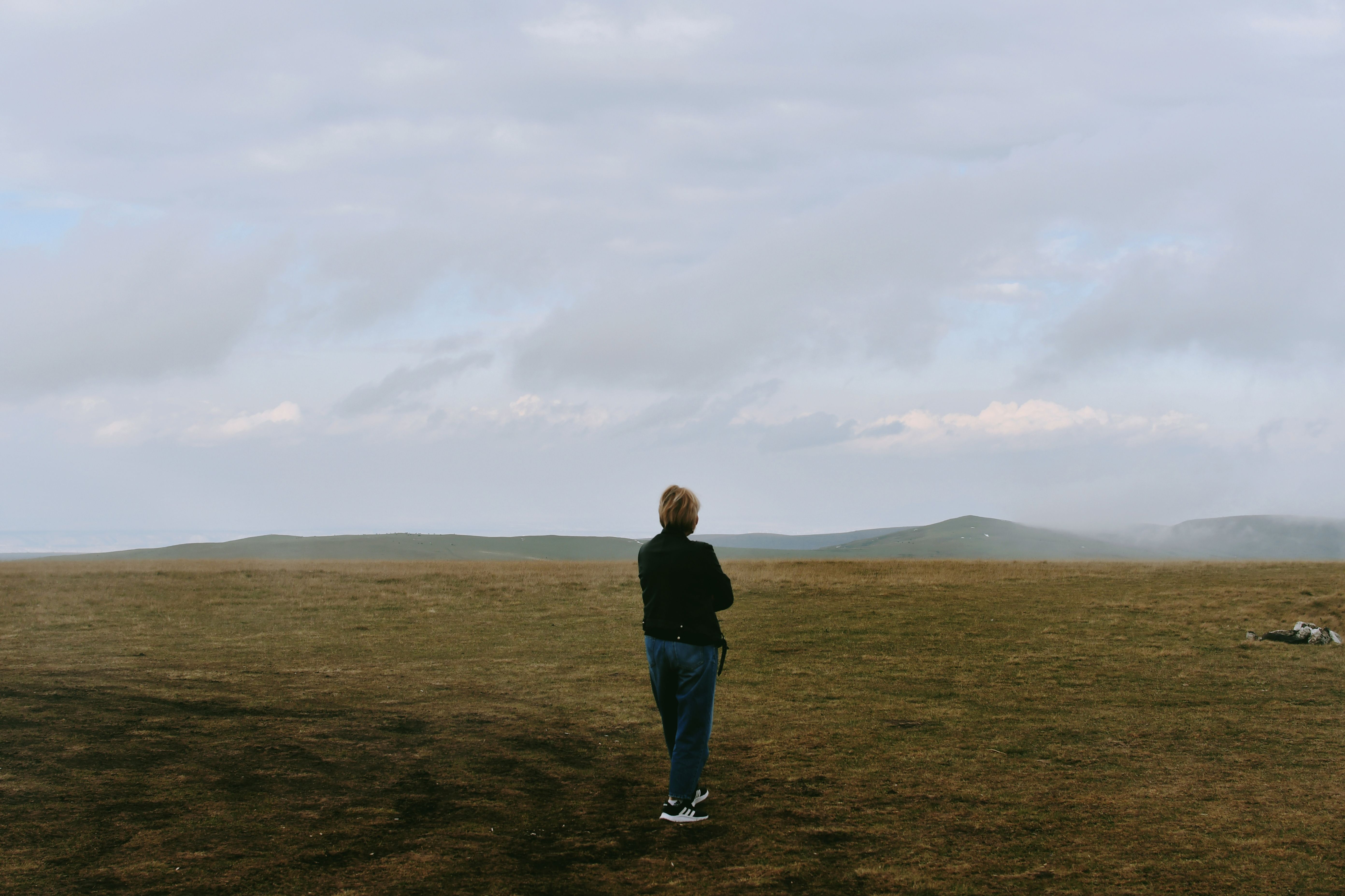 A person standing in a field looking at the sky · Free Stock Photo