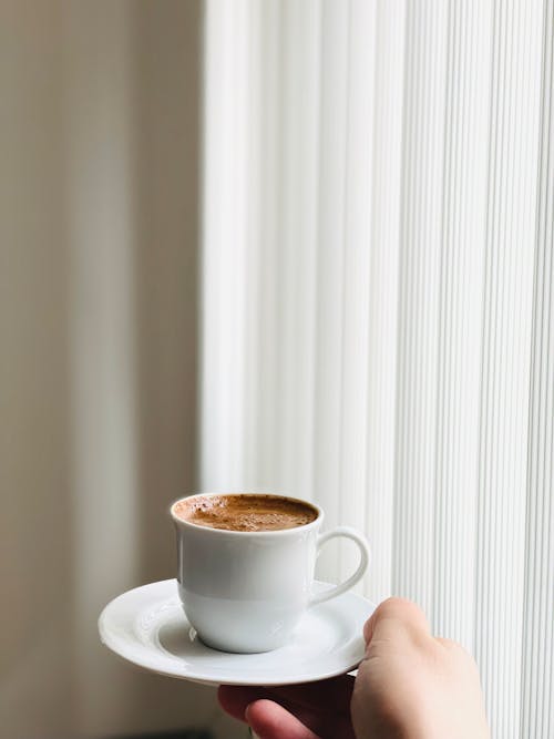 Hand Holding Plate with Coffee Cup