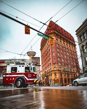 Dynamic street view of a fire truck near iconic Vancouver buildings and landmarks.