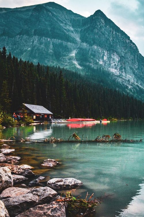 Free Tranquil view of Lake Louise with mountains and forest reflections on calm water. Stock Photo