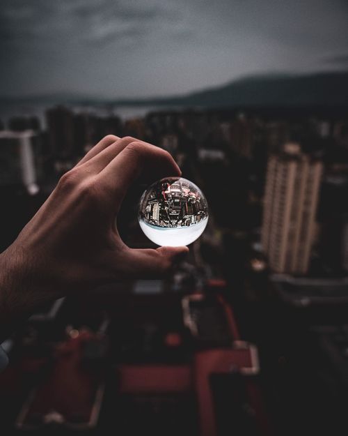 Free A unique perspective of a cityscape captured through a crystal ball, featuring a moody dark tone. Stock Photo