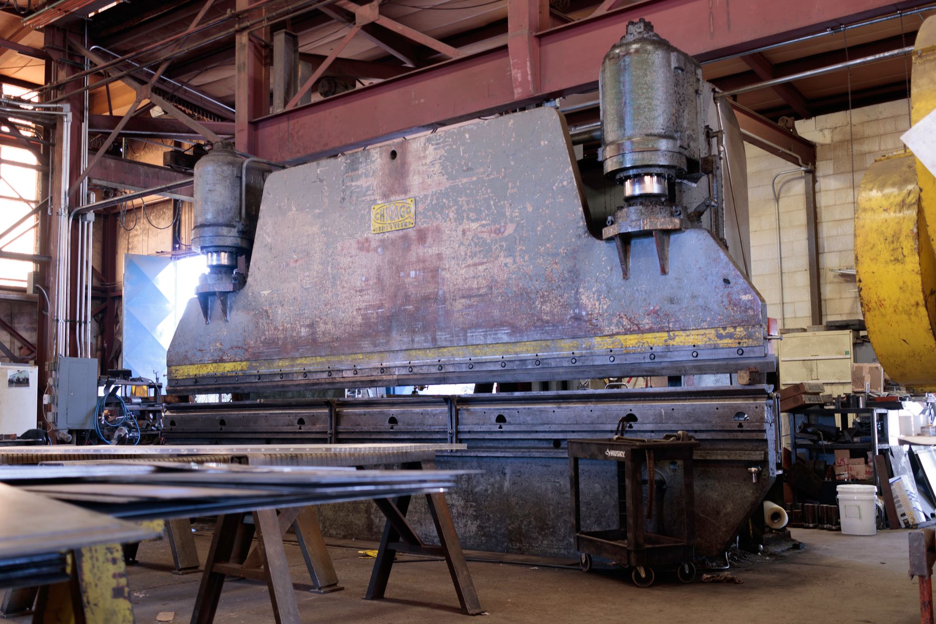 CNC Press Brake Back Gauge Calibration Guide插图 Massive metal press in a factory showcasing heavy machinery and industrial environment.