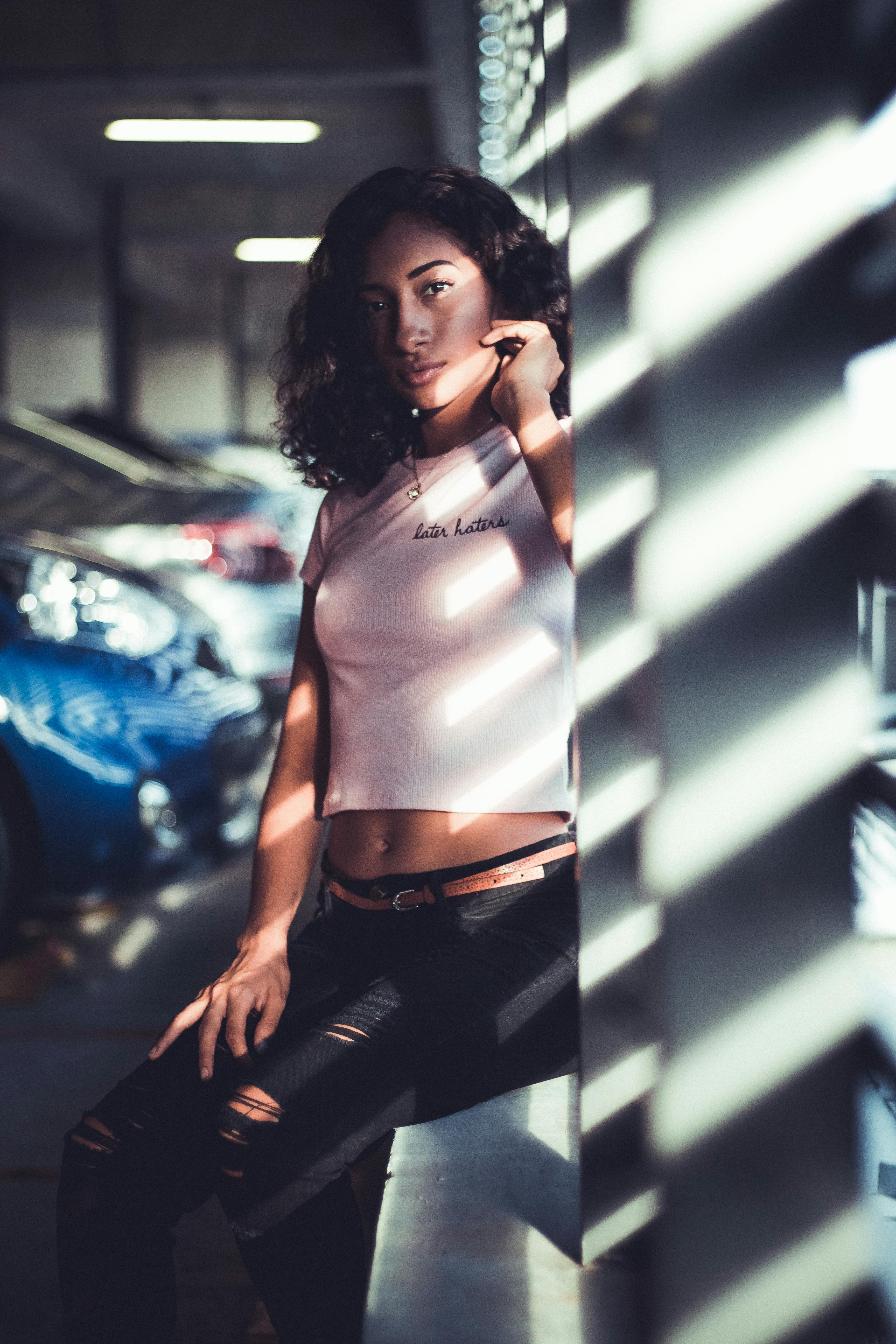 A woman in a crop top and jeans poses for a photo · Free Stock Photo