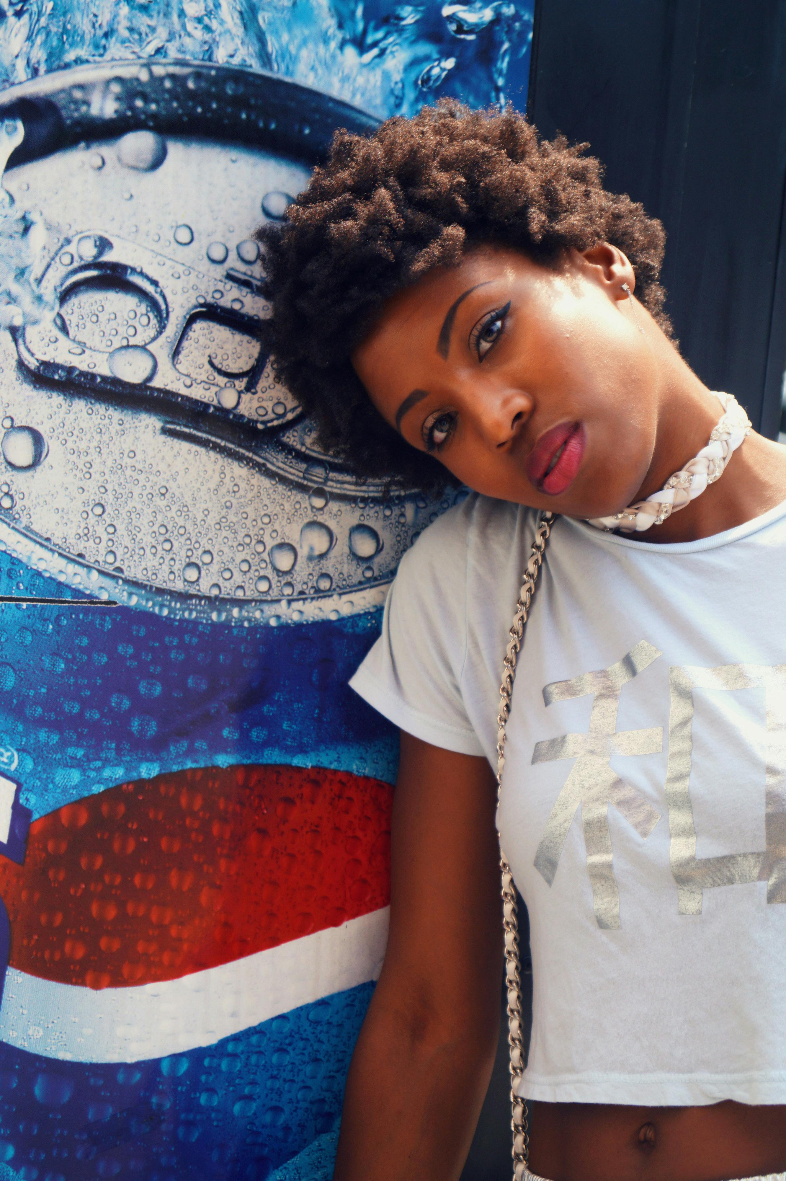 woman wearing crop top near pepsi poster