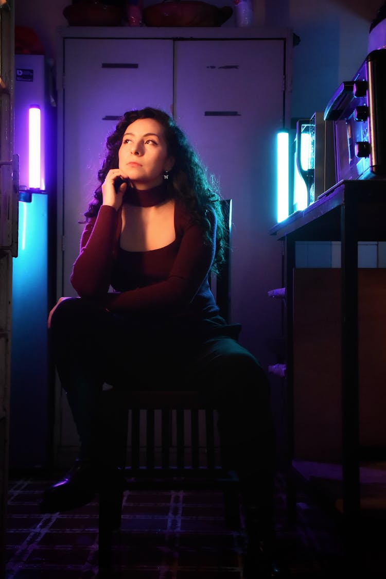 Woman Sitting In Dark Room