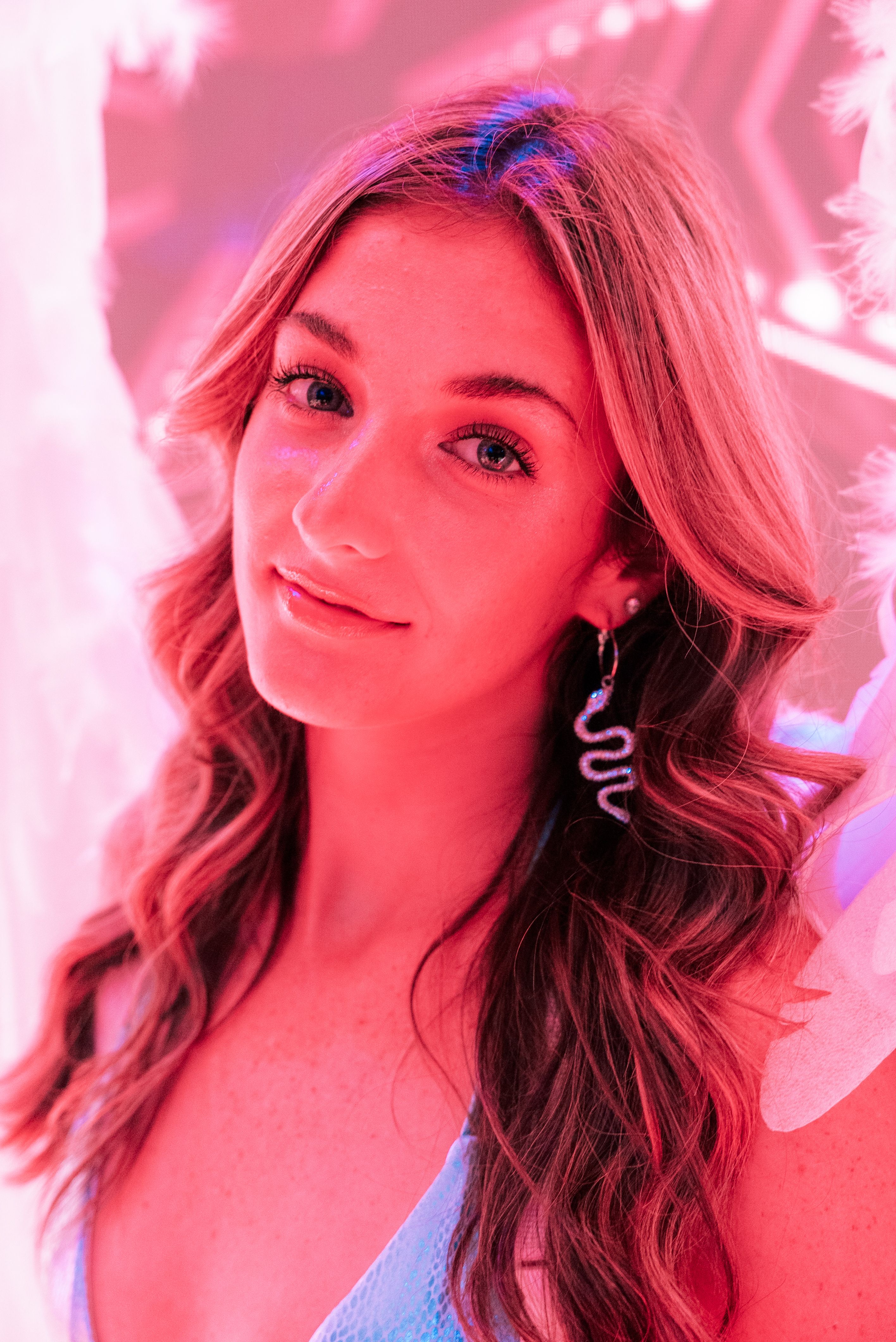 Portrait of a beautiful young woman with wavy hair in a vibrant, artistic setting. Ideal for fashion and lifestyle themes.