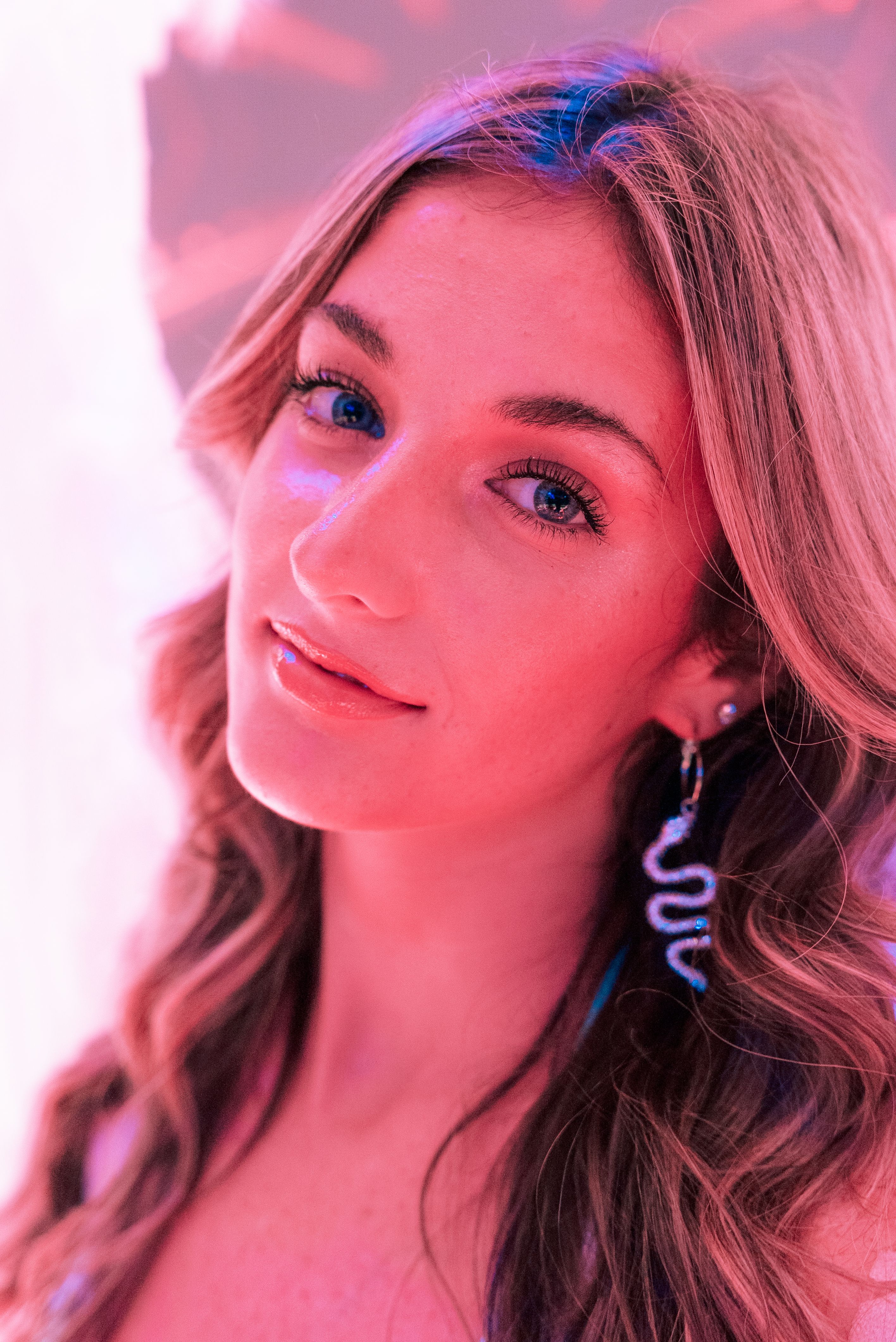 A woman with long hair and earrings posing for a photo · Free Stock Photo