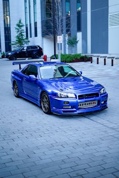 A vibrant blue sports car parked in a modern city downtown area.