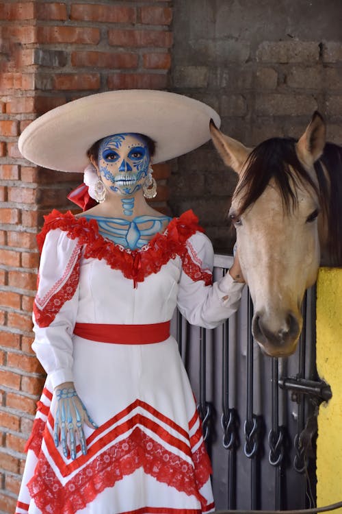 A woman in a mexican costume and a horse