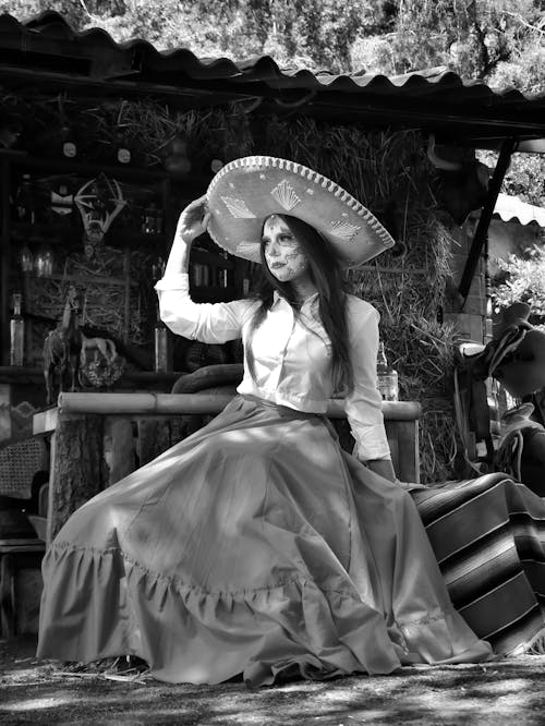 A woman in a mexican dress sitting on a bench