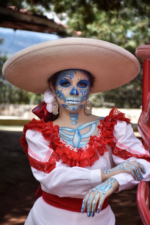 A woman in a mexican costume with blue and white makeup