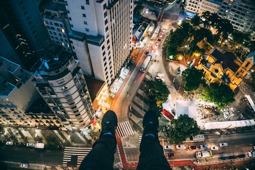 Hombre Sentado En Edificio Alto Tomando Fotos A Continuación