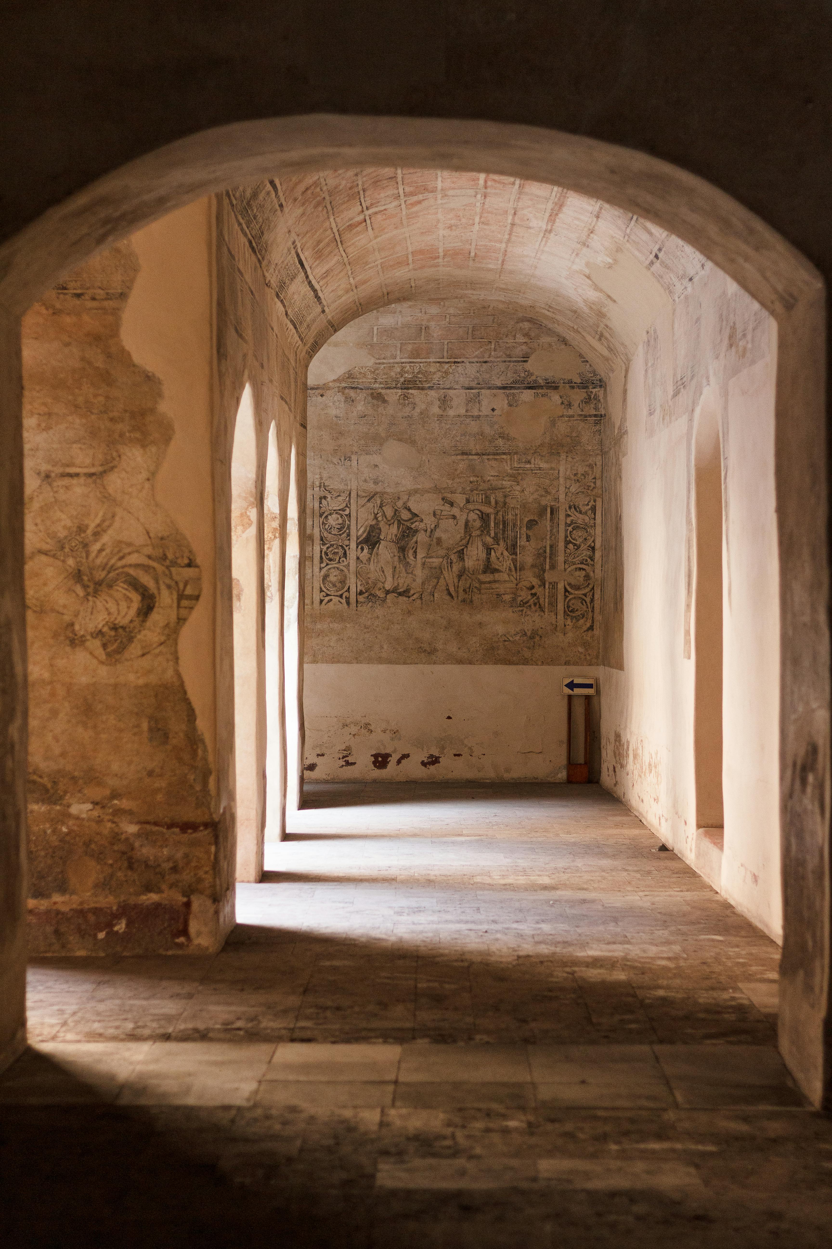Beautiful arched hallway with ancient paintings in Acolman, Mexico.