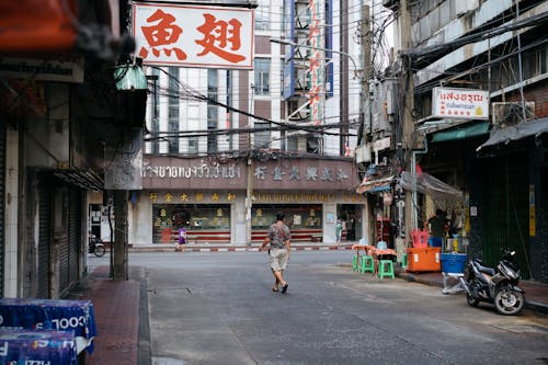 A man walking down a street in an asian city