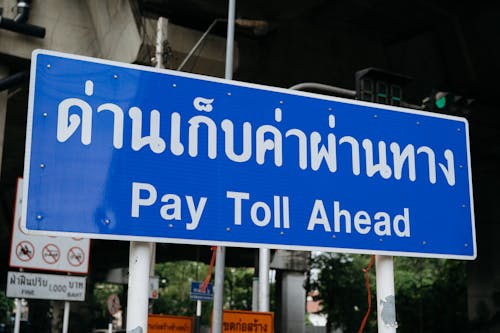 A sign that says pay toll ahead in thai