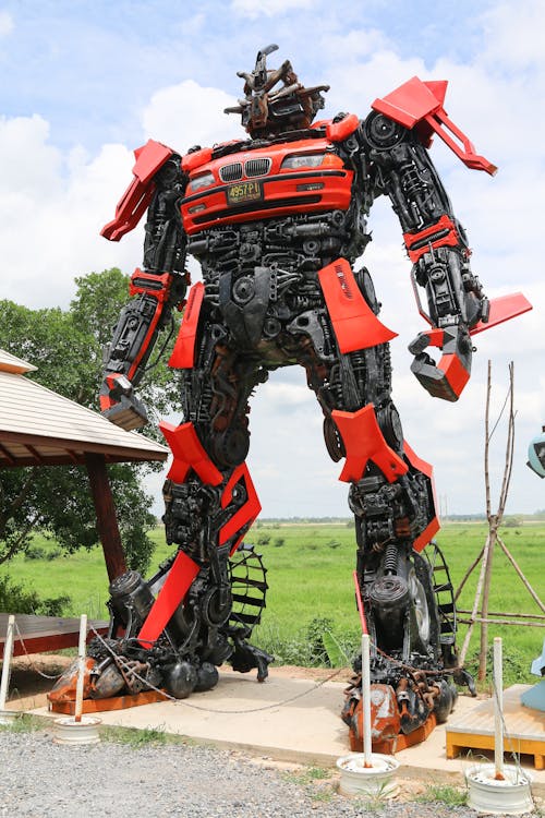 Free A towering robot sculpture made from recycled materials stands outdoors on a clear day. Stock Photo