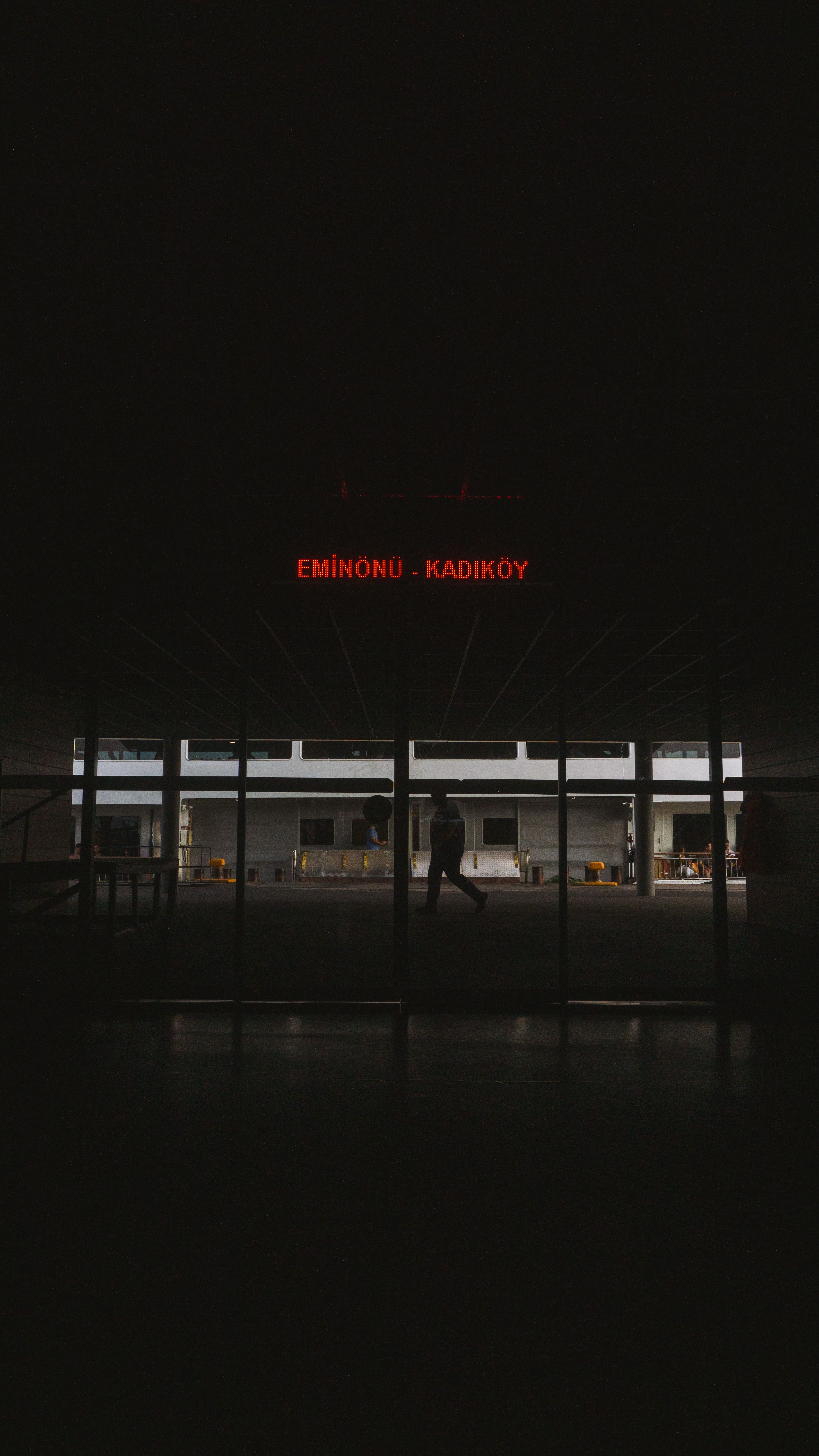 Dimly lit corridor with an illuminated sign, hinting at airport travel.