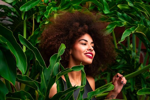 Selective Focus Photography of Woman Surrounded by Green-leafed Plants