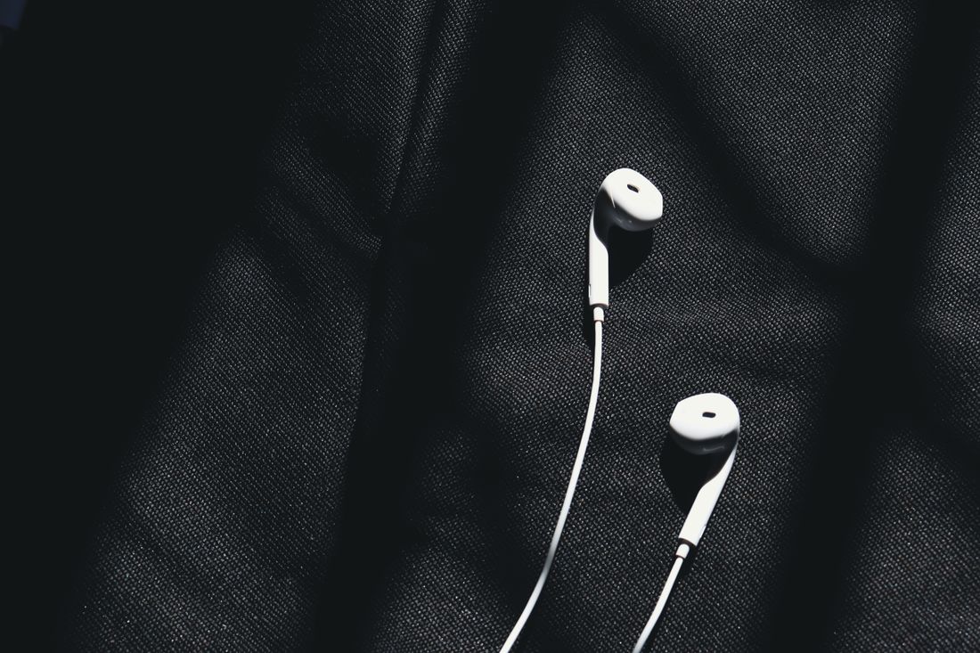 White wired earphones on dark fabric