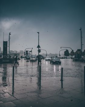 Dramatic scene of a wet urban street in Hamburg, capturing rain and car traffic.