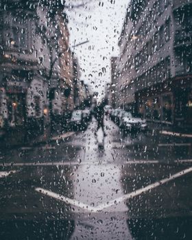 Blurred view through a rainy window onto a street in Hamburg, capturing the essence of a gloomy urban day.