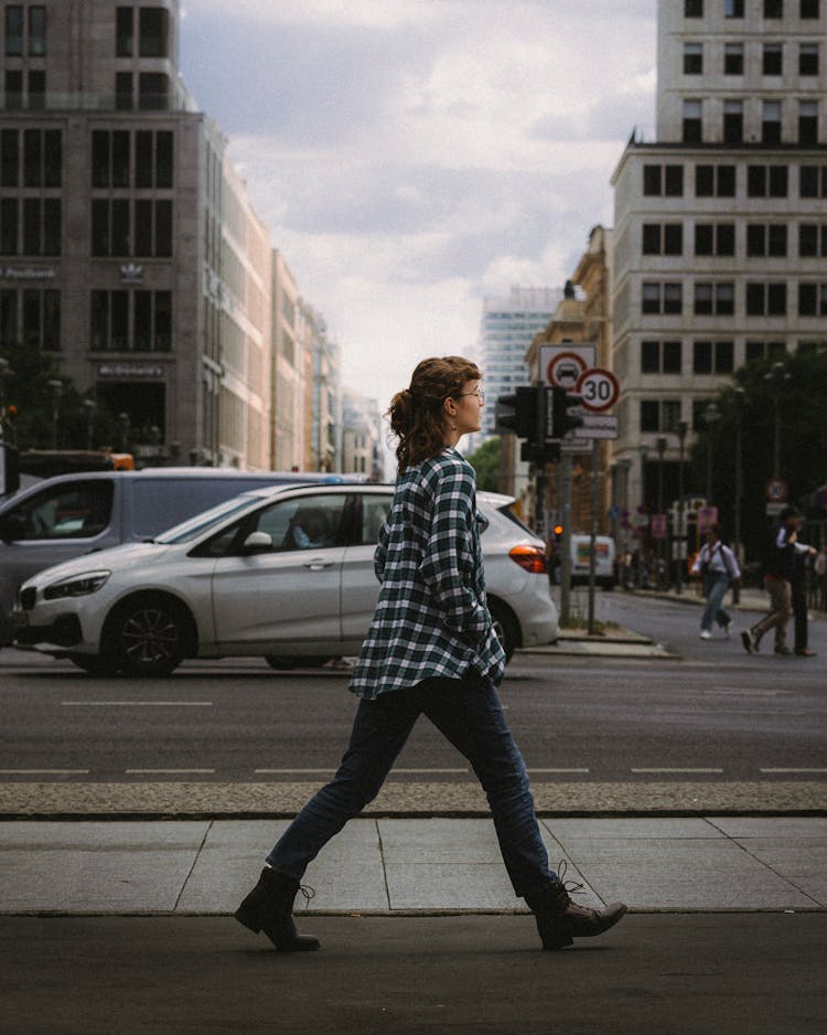 Woman In Checkered Shirt Walking On Sidewalk