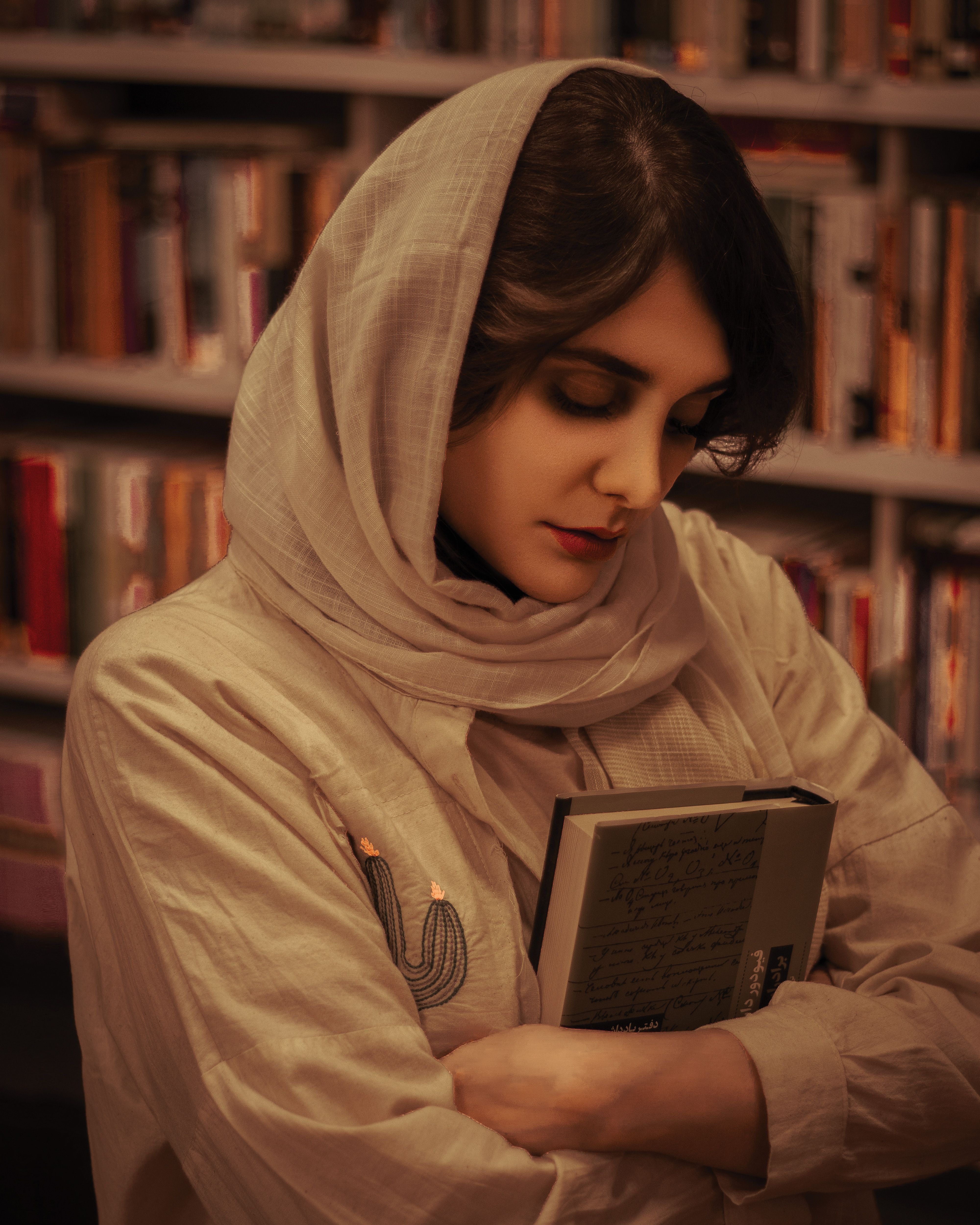 A woman in a hijab holding a book · Free Stock Photo