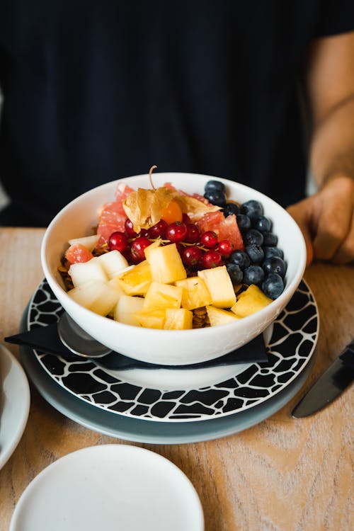 A bowl of fruit and berries on a plate