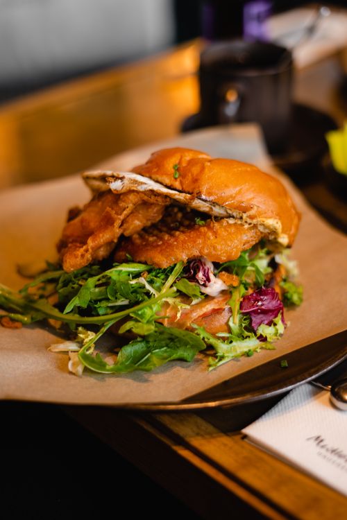 Free Delicious fried lobster sandwich with fresh arugula served on parchment paper. Stock Photo