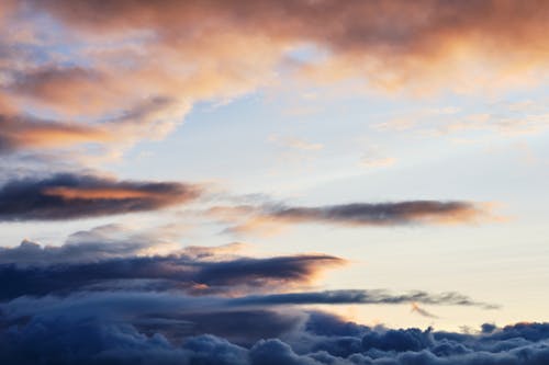 A sunset over the ocean with clouds in the sky