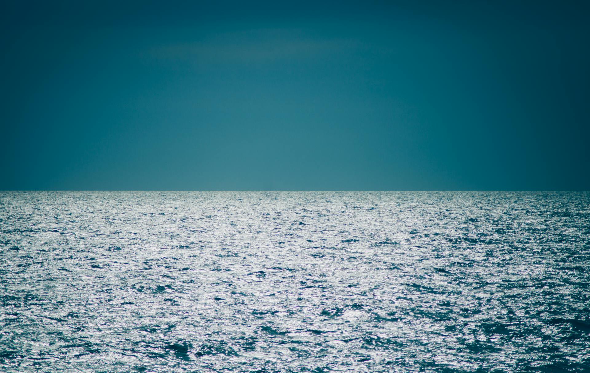 Captivating twilight view of the calm ocean, reflecting the serene hues of the horizon.