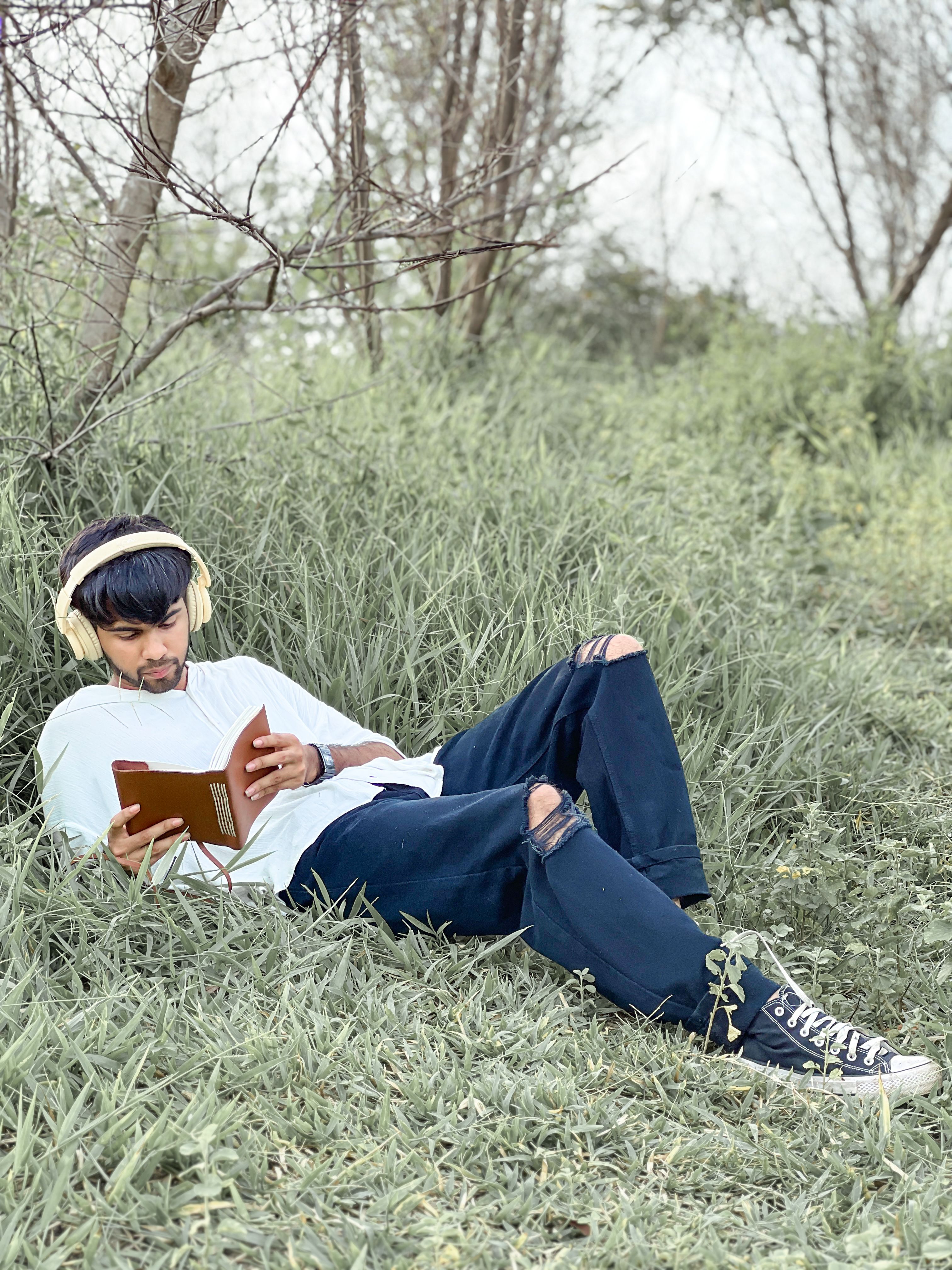 Man enjoying a peaceful day in Engelberg, Switzerland, reading in a meadow.