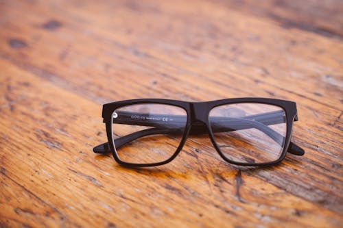 Free Black Frame Wayfarer Eyeglasses on Brown Wooden Surface Stock Photo