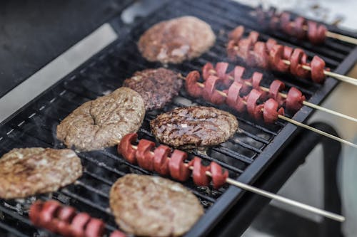 Steaks and Skewered Sausages on Grill