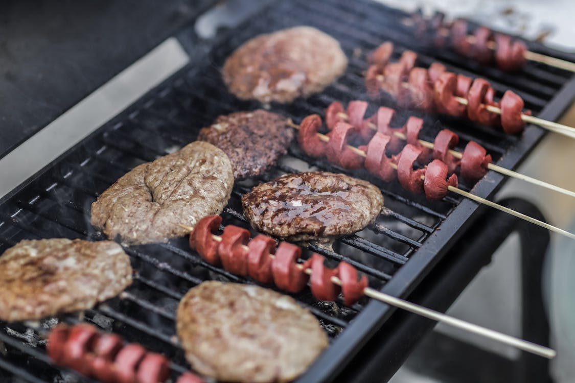 Free Steaks and Skewered Sausages on Grill Stock Photo