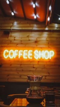 Cozy coffee shop interior featuring a vibrant neon sign and industrial style decor.