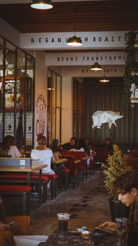 Warm interior of a coffee shop with customers, modern design, and relaxed ambiance.
