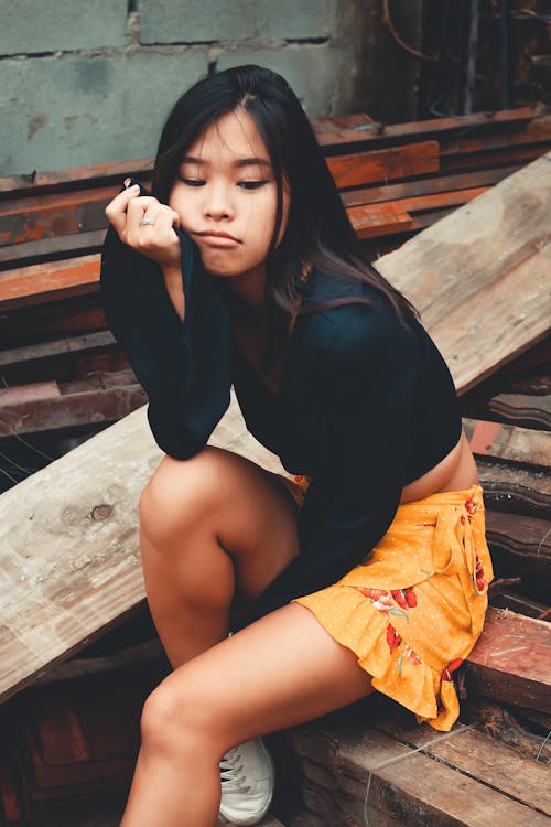 Sitting Woman in Black Long-sleeved Top on Focus Photography