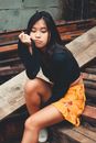 Sitting Woman in Black Long-sleeved Top on Focus Photography