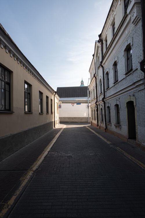 Free A quiet cobblestone street flanked by old buildings in Grodno, Belarus, capturing a serene urban scene. Stock Photo