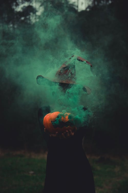 Green Smoke from Pumpkin over Person in Witch Costume