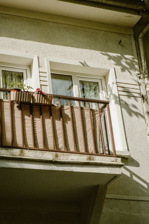 Free A sunlit balcony with potted plants casting shadows, captured in Istanbul, Türkiye. Stock Photo