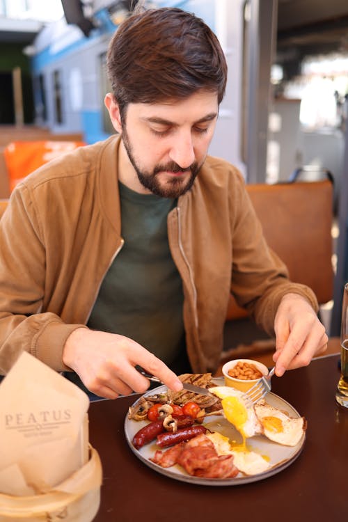 Man Eating Full English Breakfast at Restaurant