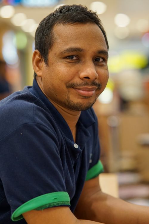 Free Portrait of a smiling man in casual attire enjoying a relaxed moment indoors. Stock Photo